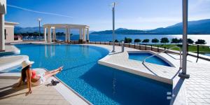 基洛纳The Royal Kelowna - Bellstar Hotels & Resorts的坐在游泳池边缘的女人