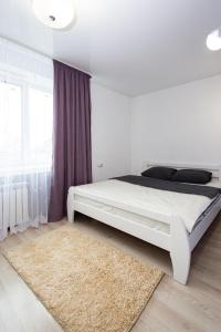 捷尔诺波尔Центр. Вулиця Руська. 2 кімнати的卧室配有白色的床和地毯。