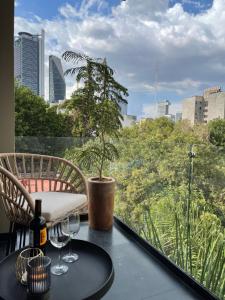 墨西哥城Condesa Cibel的树上阳台的桌子和酒杯