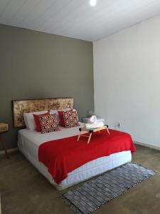 圣若热岛Sítio Aroeira Chalés的一间卧室配有一张带红色毯子的大床
