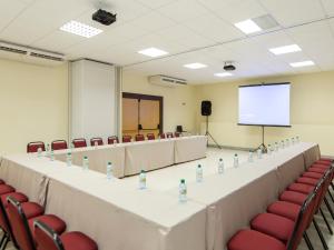 纳塔尔Rede Andrade Comfort的一间会议室,配有桌椅和屏幕