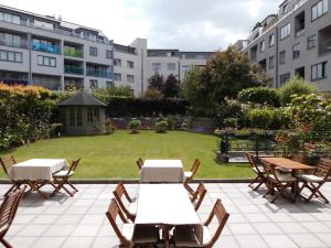 布鲁塞尔豪辛布鲁塞尔客房公寓 的一个带桌椅的庭院和一座带建筑的草坪