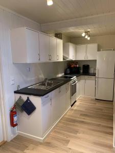 诺托登Notodden Sentrum Apartment NO 1的厨房配有白色橱柜和白色冰箱。