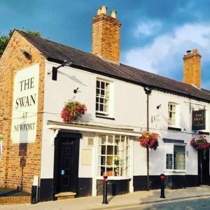 纽波特The Swan Inn Newport的白色的建筑,窗户上有鲜花