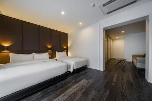 首尔钟路区阿玛尔酒店的酒店客房,设有两张床和一张沙发