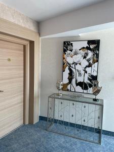 马马亚Alcor Beach Hotel的一间墙上挂有绘画的桌子的房间