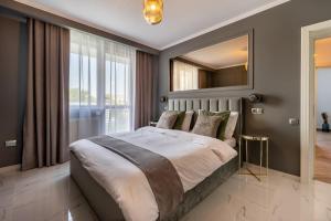 克卢日-纳波卡Urbio Private Suites的一间卧室配有一张大床和镜子