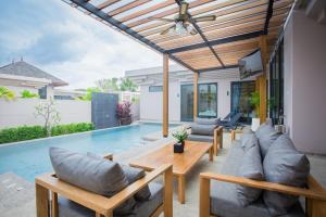邦涛海滩Gold Chariot Pool Villa, Phuket - SHA Plus Certified的一个带沙发和桌子的庭院和一个游泳池