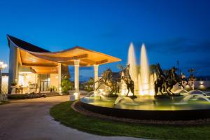 邦涛海滩Gold Chariot Pool Villa, Phuket - SHA Plus Certified的一座建筑物前的喷泉,里面饲养着马匹