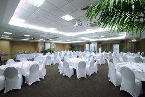 奥克兰林肯绿色品质酒店的宴会厅配有白色的桌子和白色的椅子