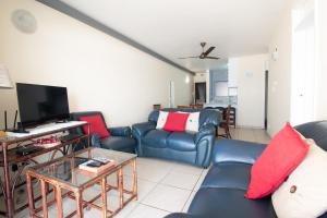 德班10 Bronze Bay Umhlanga Rocks的客厅配有蓝色的沙发和电视