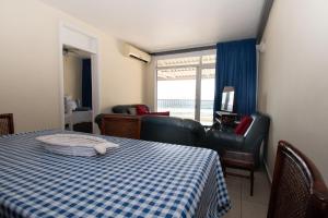 德班10 Bronze Bay Umhlanga Rocks的卧室配有蓝色和白色的格子床和椅子