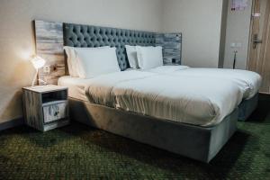 奇姆肯特Express City Hotel的酒店客房设有一张大床和大型床头板