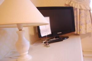 圣马丁格恩西拉米歇尔酒店的电脑显示器和书桌上的灯