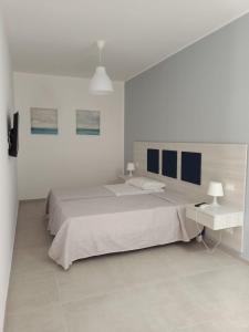 PartannaLa Lume的白色卧室设有一张大床和一盏灯。