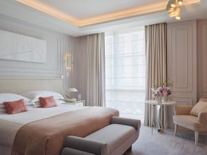 伦敦奥德维奇一号酒店的卧室配有床、椅子和窗户。