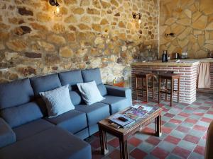 El ColmenarCasas Rurales- "Casa Larios"的客厅配有蓝色的沙发和桌子