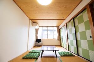 富士河口湖Habitacion NIIYA Mt Fuji的小房间设有一张桌子和绿色靠垫