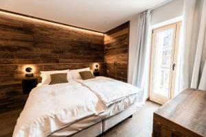 摩德纳迪-坎皮格里奥ALPINE DAYS Mountain Home的一间卧室设有一张床和木墙