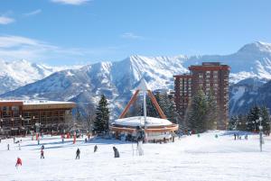 勒克比尔Studio 4pers vue piste的一群人在山前的雪中滑雪