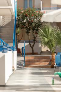 古瓦伊玛丽克里公寓酒店的一座棕榈树和蓝色椅子的建筑,楼梯