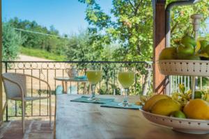 San Lorenzo in CampoCasa Magica的一张桌子,上面放着两杯葡萄酒和一篮水果
