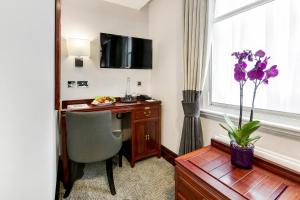 伦敦Gem Fitzrovia Hotel的酒店客房设有书桌和窗户。