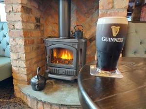 康多纳Joyce's Carndonagh Inishowen的坐在炉子旁的桌子上喝杯啤酒