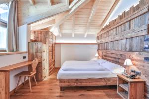 卡瓦莱塞Garni Maso San Michele的一间卧室配有一张床和一张书桌