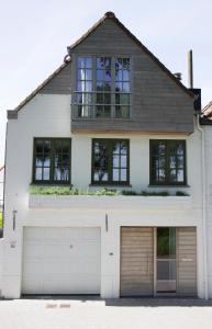 达默Cosy & charming holiday house in Damme的两扇车库门的白色房子