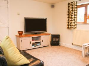 毕晓普斯堡Linley Lane Cottage的客厅配有壁橱上的平面电视