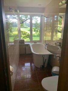 泰尔韦泰普特克罗格斯旅馆的一间带两个盥洗盆、浴缸和窗户的浴室
