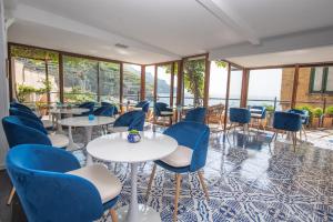 米诺利帕拉佐维吉优斯酒店的餐厅设有蓝色的椅子和桌子以及窗户。