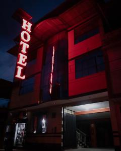 圣拉蒙Refugio Hotel的上面有红 ⁇ 虹灯标志的建筑