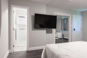 滑铁卢PRIVATE ROOM ENSUITE UPTOWN WATERLOO - e5的卧室配有壁挂式平面电视。