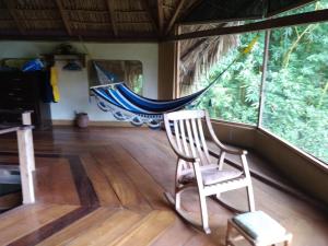 Santa CruzFinca del Sol Eco Lodge的带吊床的客房内的摇椅