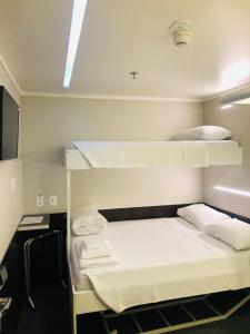 坎皮纳斯Hotel Aero Sleep Campinas的客房设有两张双层床和电视。