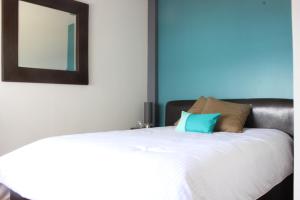 墨西哥城Downtown Mexico City, full apartment的卧室配有一张带镜子的白色床