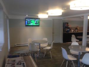 巴索尔特格林德莱克酒店的一间设有桌椅和墙上电视的客房