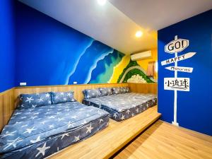 小琉球岛小琉球寄居蟹民宿的一间设有两张床和蓝色墙壁的客房