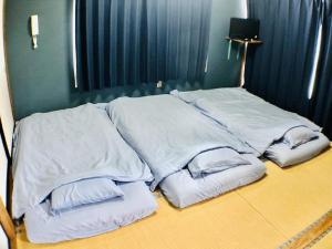 富士河口湖Habitacion NIIYA Mt Fuji的床上的一堆白色枕头