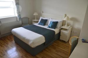 Allihies海景旅馆的一间卧室配有一张带蓝色枕头的大床