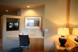 本德River Ridge 416B condo的客房设有书桌、电视和灯具。