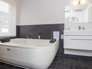 博利尔马克10 person holiday home in R m的浴室配有白色浴缸及水槽