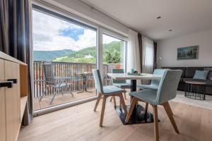 布尔古斯奥Lapis Monti - Apartments & Suites的客厅配有桌椅和大窗户