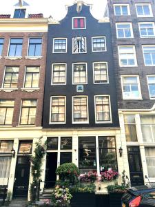 阿姆斯特丹Barrio Amsterdam的一座高大的建筑,前面有鲜花