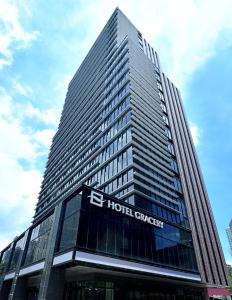 台北格拉斯丽台北饭店的一座高大的建筑,上面有酒店的协同标志