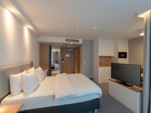 奥芬巴赫Holiday Inn Express - Offenbach, an IHG Hotel的卧室配有白色的床和平面电视。