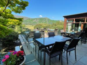凯西克玛丽山酒店的庭院配有桌椅,背景为山脉