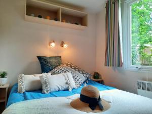 圣帕尔杜Camping du Lac de Saint-Pardoux的一间卧室配有一张蓝色的床,上面有帽子